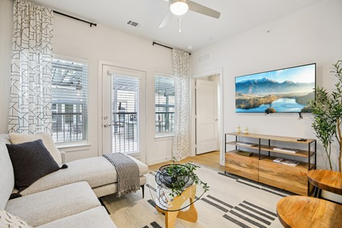 A living room with a couch, a table, and a large painting on the wall.