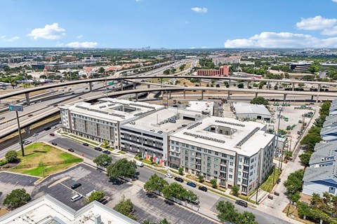 A large, multi-story building with a parking lot in front of it.