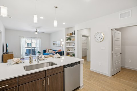 A kitchen with a white counter top and wooden cabinets.