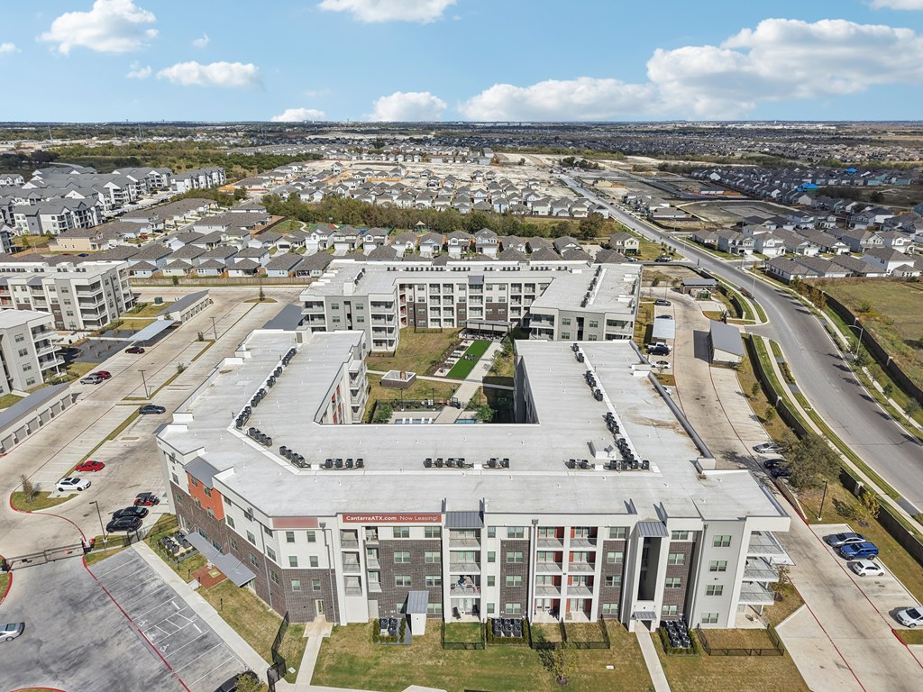 A large, modern building with a parking lot in front of it.
