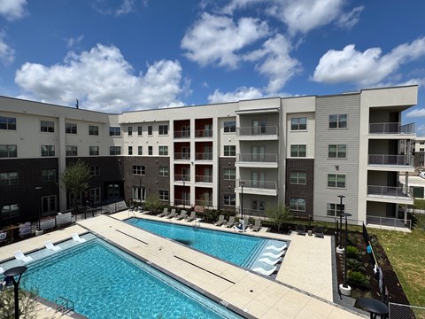 A large swimming pool in front of apartment buildings.