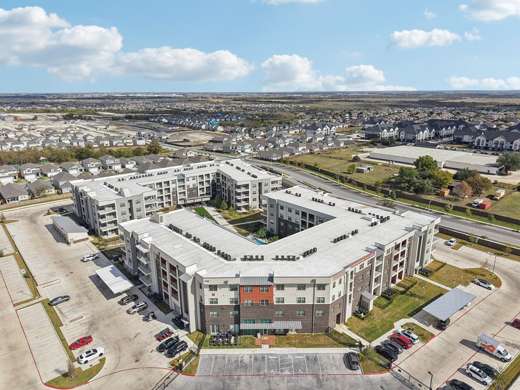 A large, multi-story building with a parking lot in front.