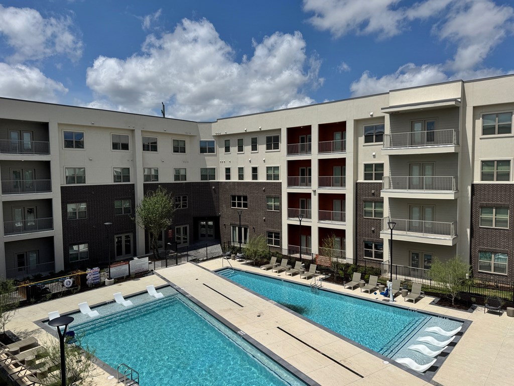 A large swimming pool in front of apartment buildings.