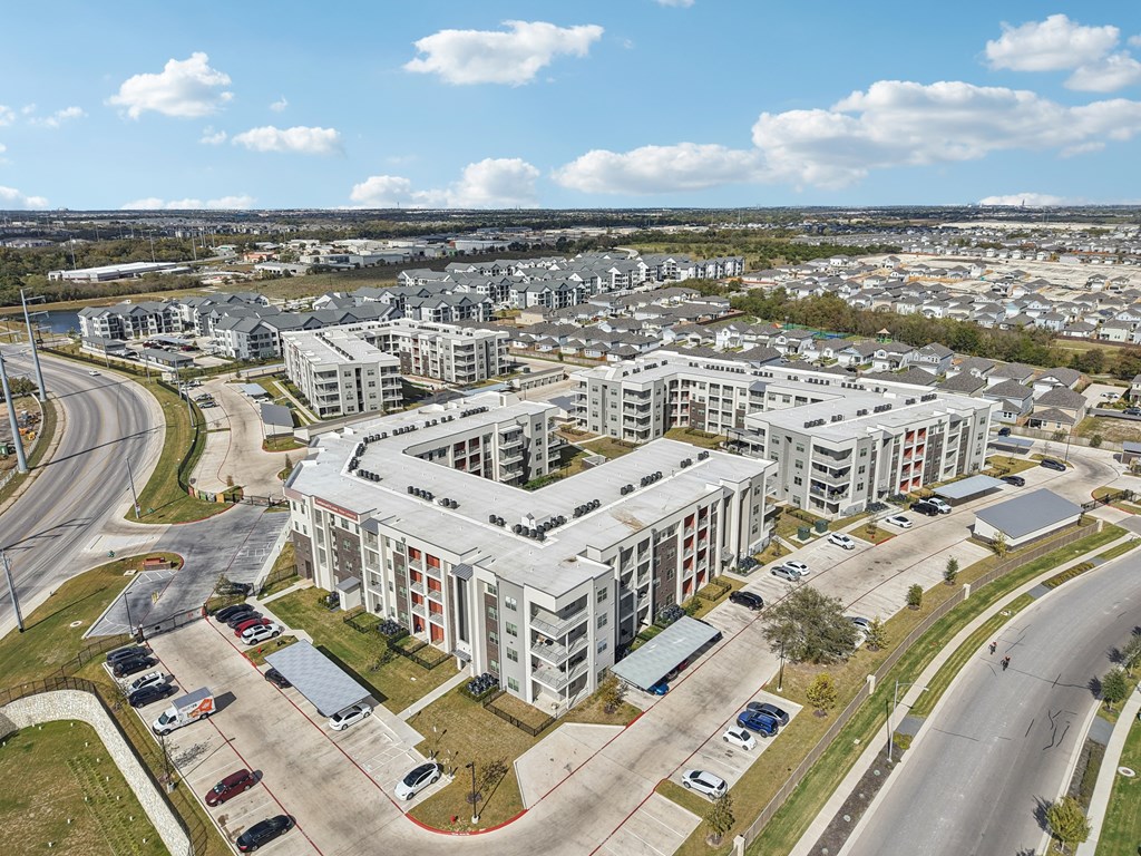 A large white building with a parking lot in front of it.
