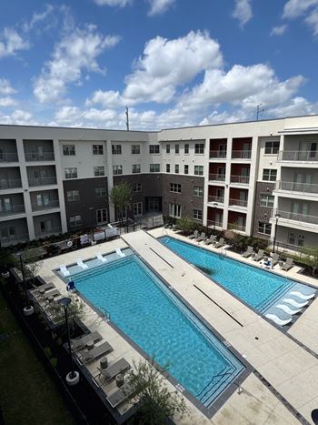 A large swimming pool in front of apartment buildings.