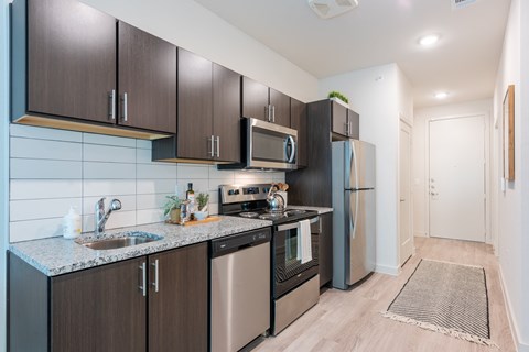 a modern kitchen with stainless steel appliances and black cabinets