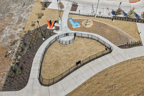 A playground with a blue and white slide and a red and white slide. at ThreeTwenty at the Vybe Apartments, Kyle, TX, 78640