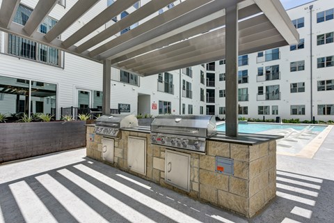 Outdoor kitchen with built in grills and pergola at Augustine Apartments, Austin, 78748