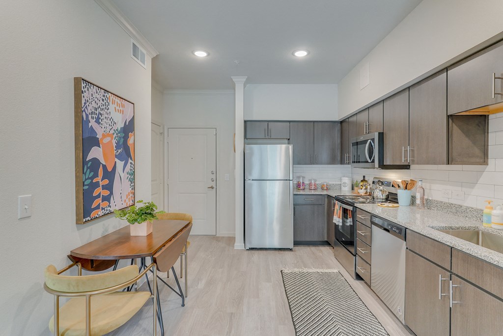 a kitchen with stainless steel appliances and a dining room table