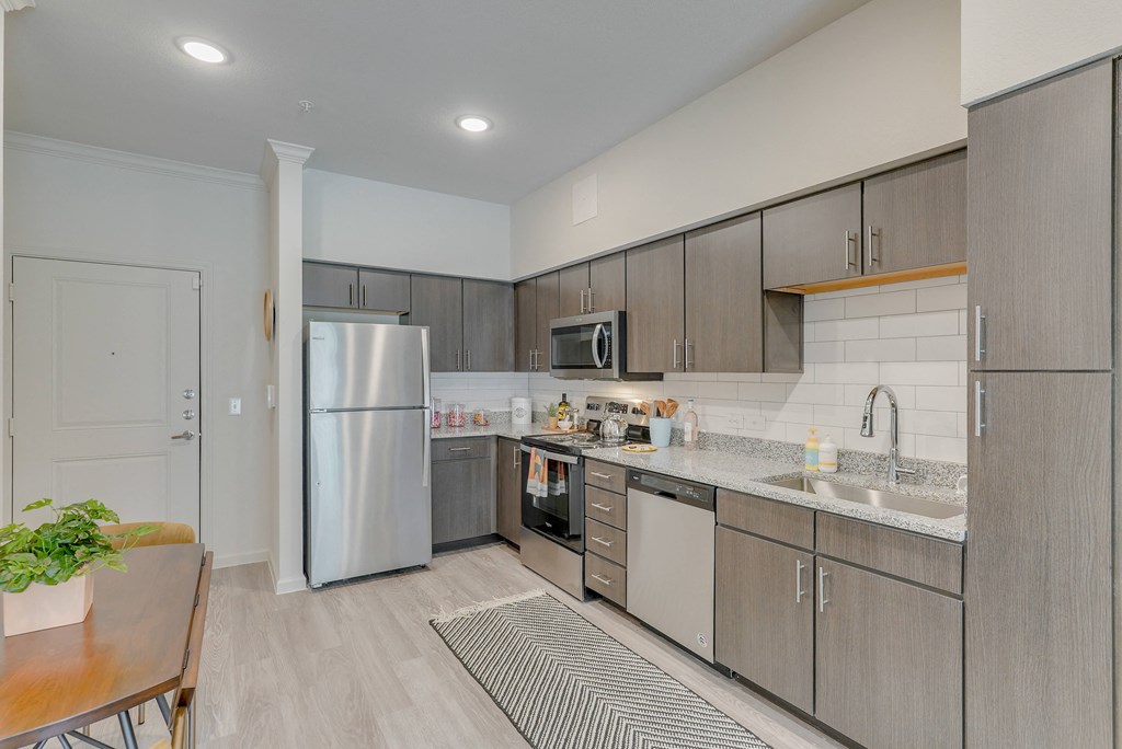 a modern kitchen with stainless steel appliances and wooden cabinets