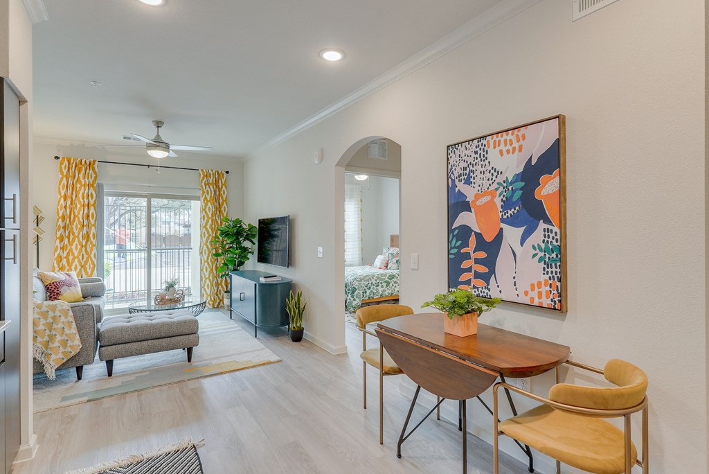 a living room and dining room with a table and chairs