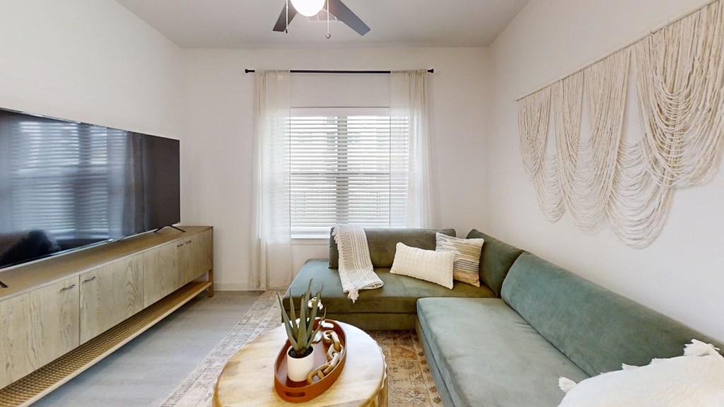 A living room with a green couch and a wooden coffee table.