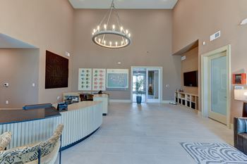 A large, well-lit room with a reception desk and a chandelier hanging from the ceiling.