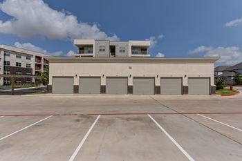 A large building with a flat roof and a parking lot in front.