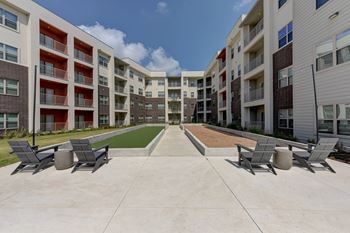 A sunny day at the apartment complex with a swimming pool and lounge chairs.