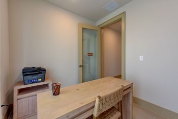 A room with a wooden desk and a printer on it.