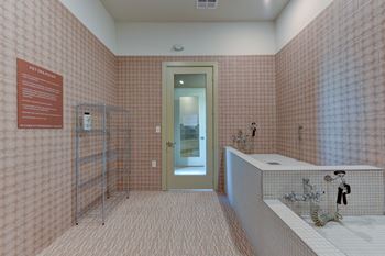 A bathroom with pink tiles and a white sink.
