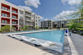 A swimming pool in front of apartment buildings.