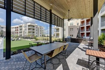 A patio with a table and chairs is surrounded by buildings.