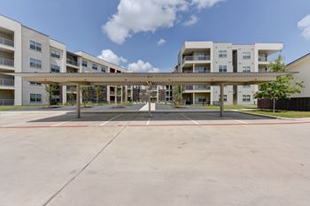 A parking lot in front of apartment buildings.