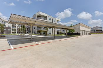 A parking lot in front of a building with a canopy.