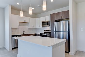 A modern kitchen with a large island and stainless steel appliances.
