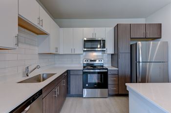 A modern kitchen with stainless steel appliances and wooden cabinets.