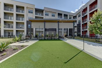 A grassy area in front of apartment buildings.