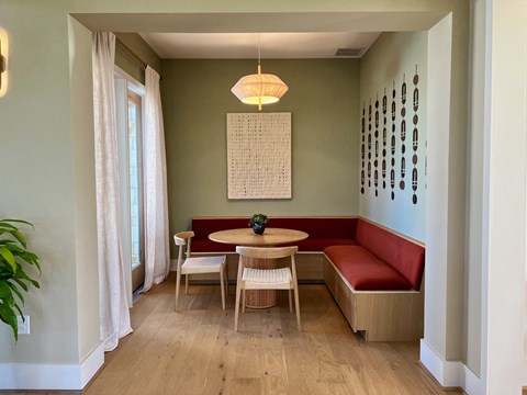 a small dining room with a red bench and a wooden table at Bridge at Delco Flats Apartments, Austin, TX