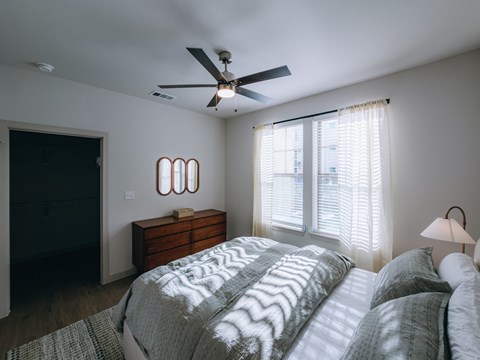 Bedroom with ceiling fan and natural light at Northwoods Apartments, Texas