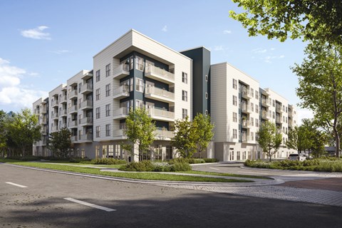 A modern apartment building with a parking lot in front.