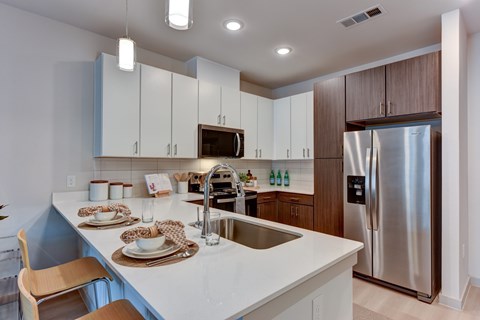 A modern kitchen with a stainless steel refrigerator and wooden cabinets.
