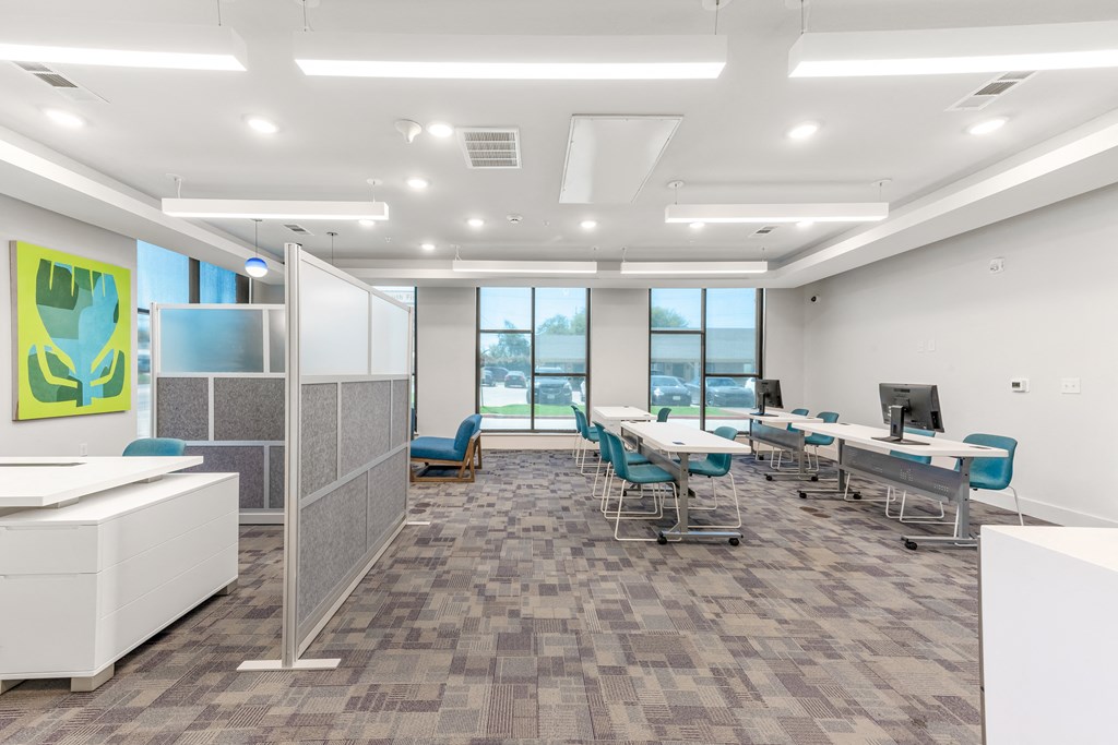 an open office space with white walls and blue chairs