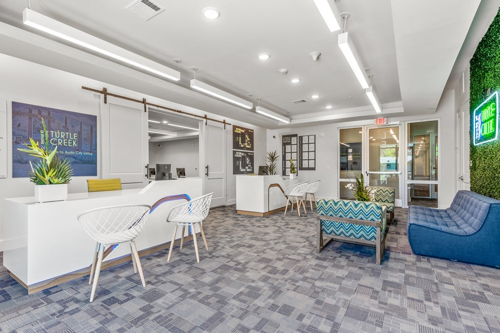 a spacious lobby with a blue couch and chair