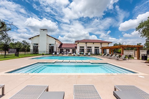 a swimming pool with lounge chairs and a building in the background at Avery Ranch, Texas, 78717
