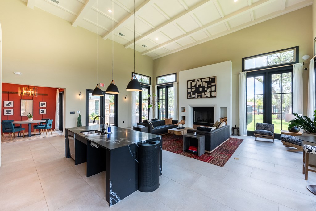 a kitchen and living room with a large black island with a granite countertop at Avery Ranch, Austin