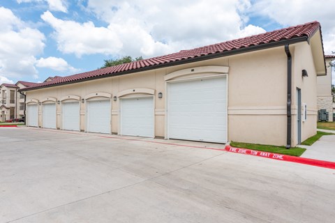 a row of three garage doors on the side of a building at Avery Ranch, Texas, 78717