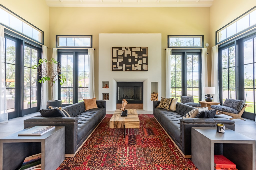 a living room with a fireplace and large windows at Avery Ranch, Austin Texas