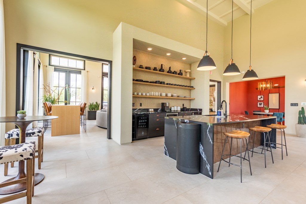 a kitchen with an island and stools in a 555 waverly unit at Avery Ranch, Texas