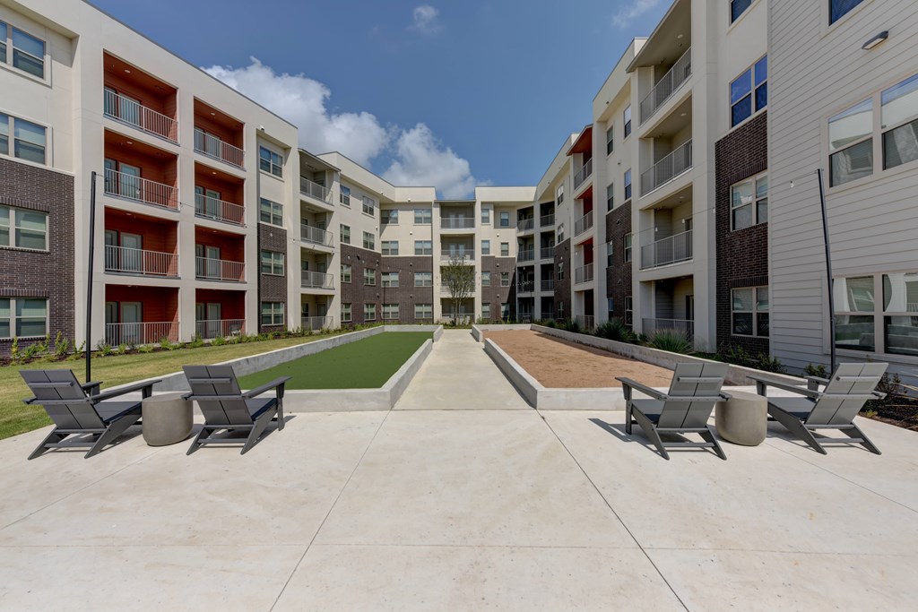 A sunny day at the apartment complex with a swimming pool and lounge chairs.