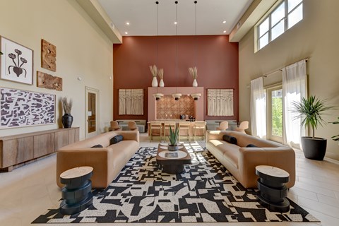A living room with a black and white rug in the center.