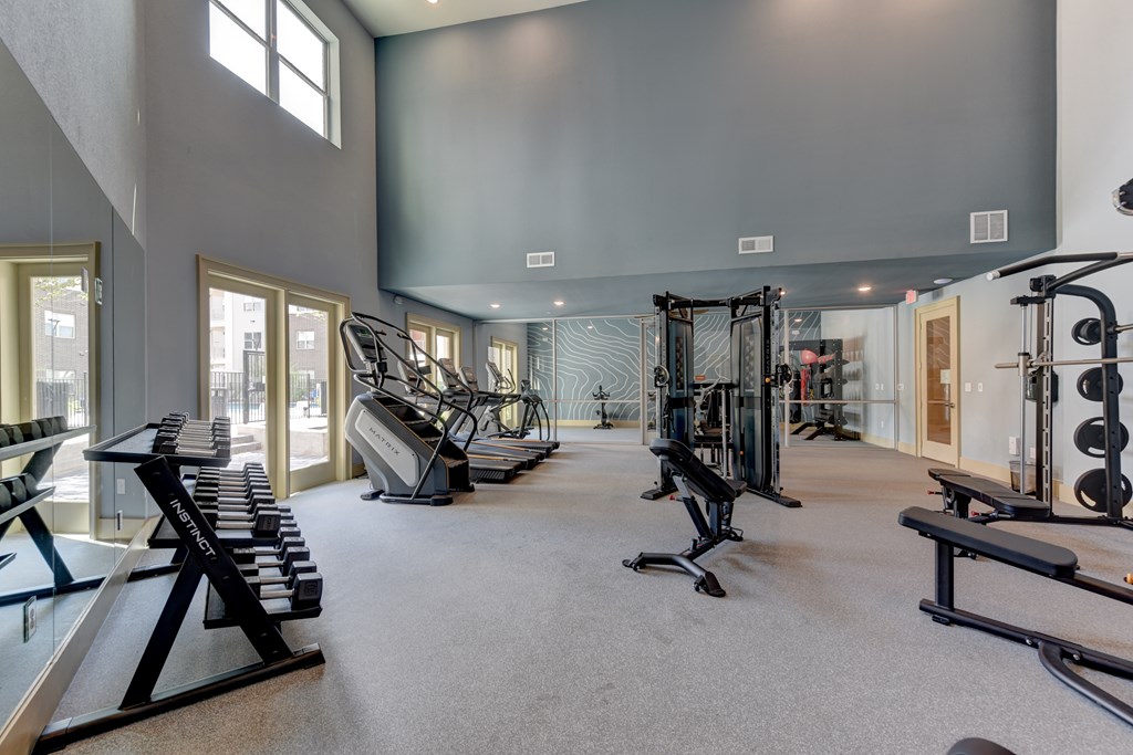 A spacious gym with a variety of equipment including treadmills, weights, and exercise machines.