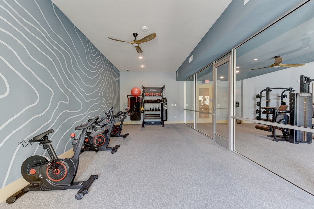 A room with exercise equipment and a wall with a wavy pattern.