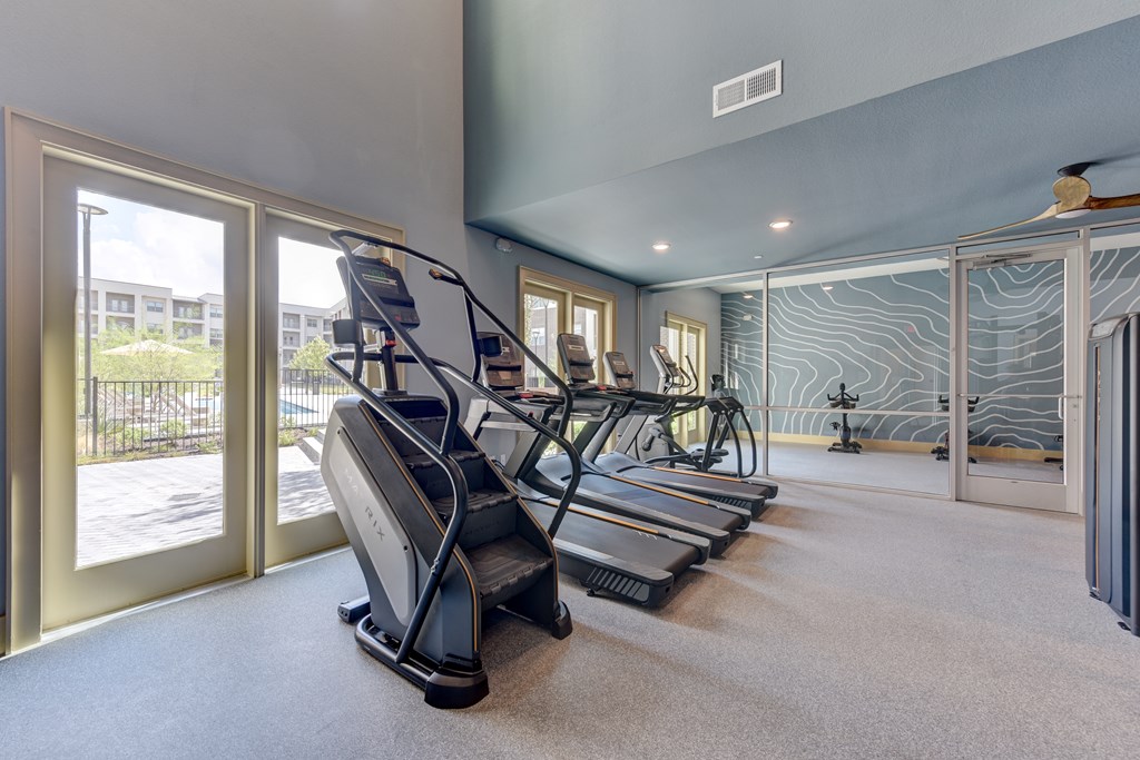 A room with treadmills and a glass wall.