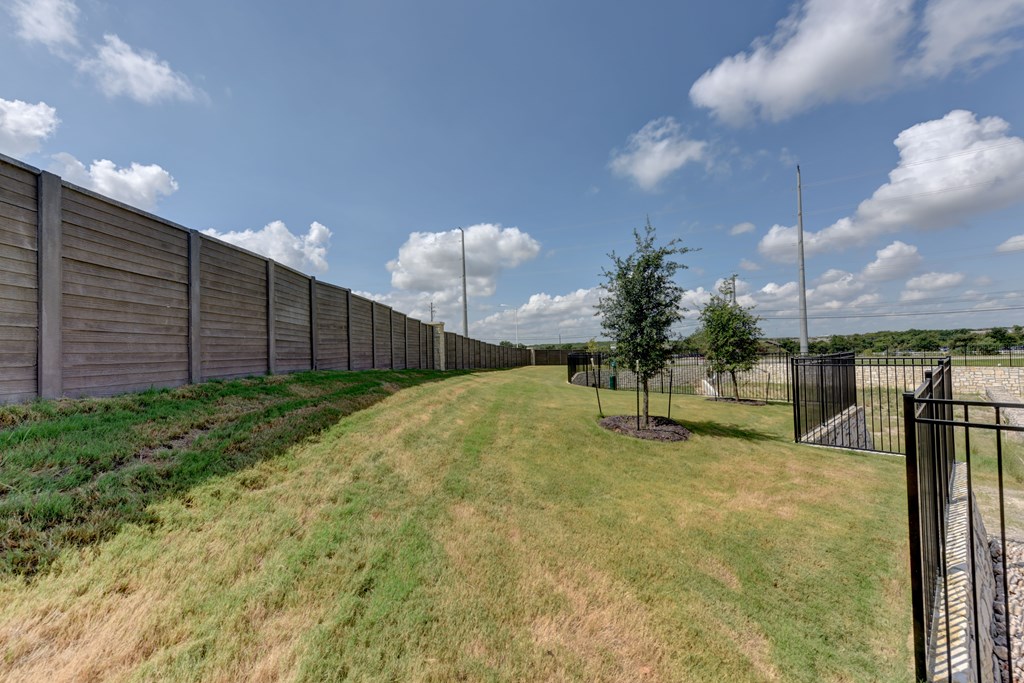 A long fence runs along a grassy hill.