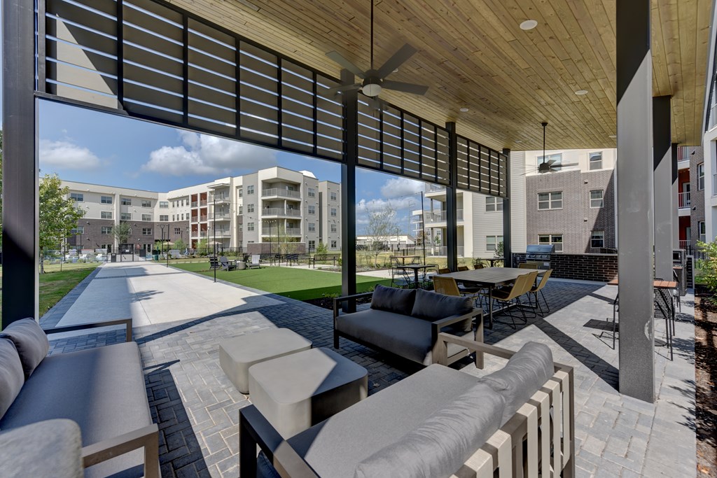 A patio with a table and chairs is covered by a roof.