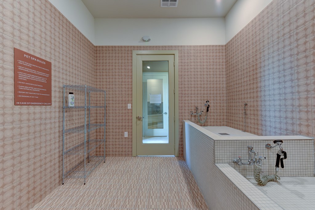 A bathroom with pink tiles and a white sink.