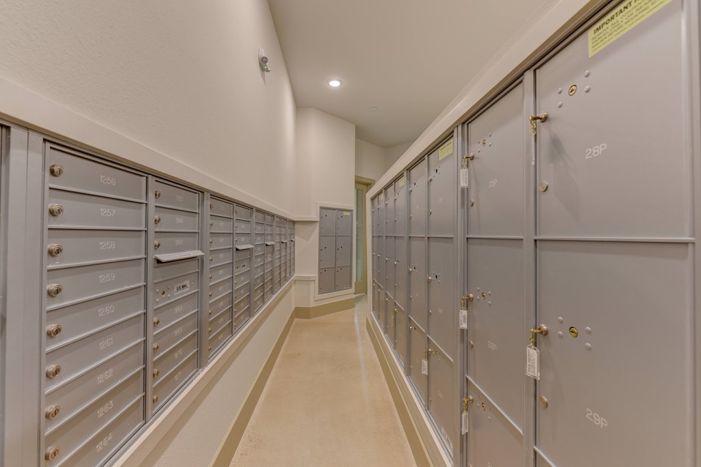 A long hallway with a series of metal lockers on the wall.