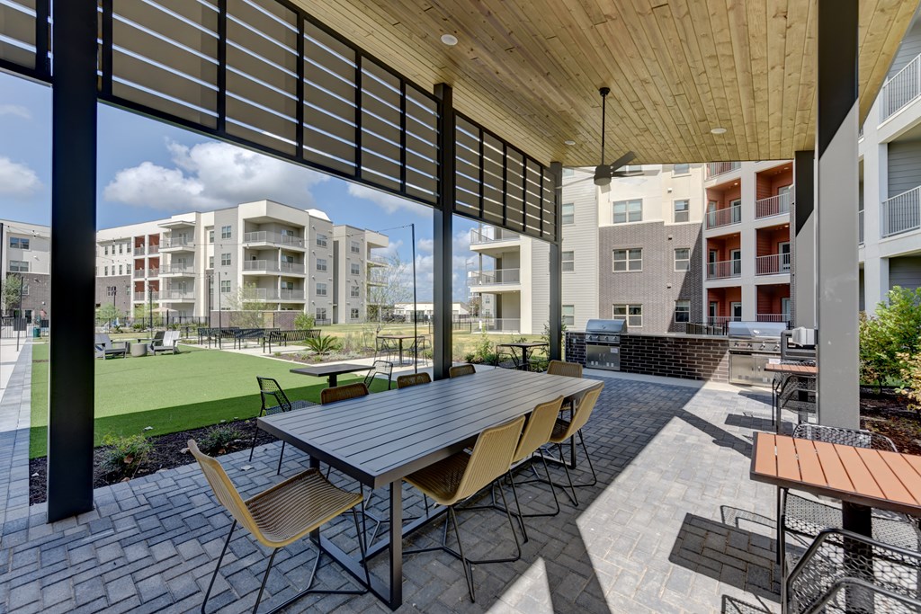A patio with a table and chairs is surrounded by buildings.