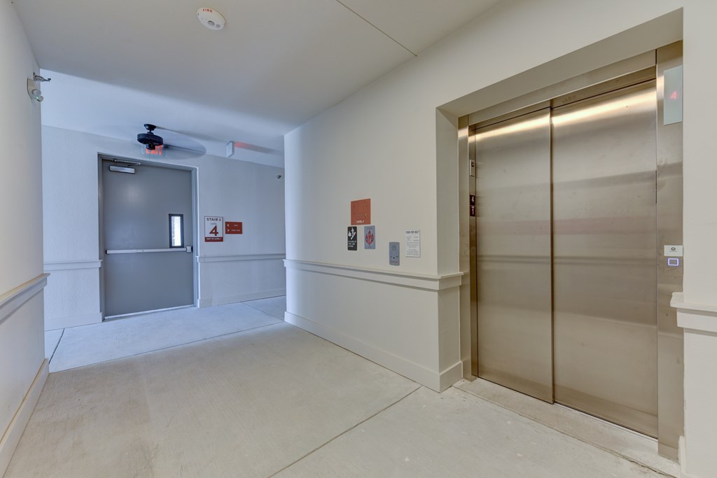 A room with a ceiling fan and a door with a sign on it.